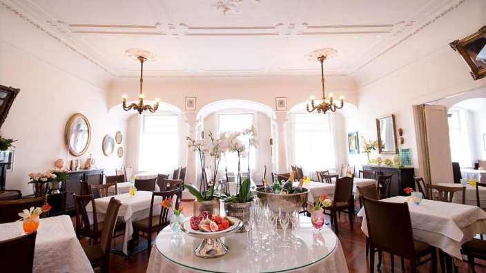 Ein Esszimmer mit vielen Tischen und Stühlen