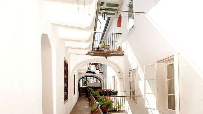 Ein weißes Gebäude mit vielen Fenstern und Balkonen