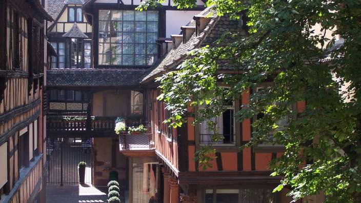 Ein kleines Gebäude mit einem Balkon zwischen zwei anderen Gebäuden