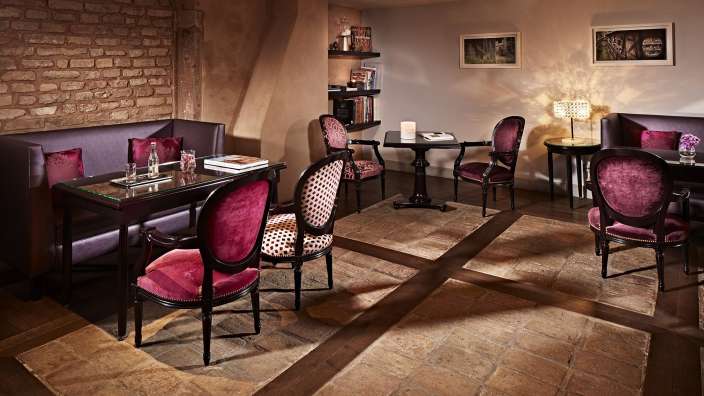 Ein Wohnzimmer mit lila Stühlen und Tischen