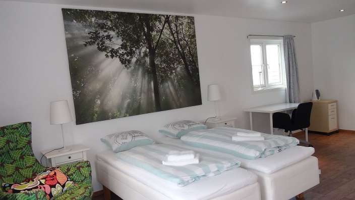 Ein Schlafzimmer mit zwei Betten und einem Gemälde an der Decke