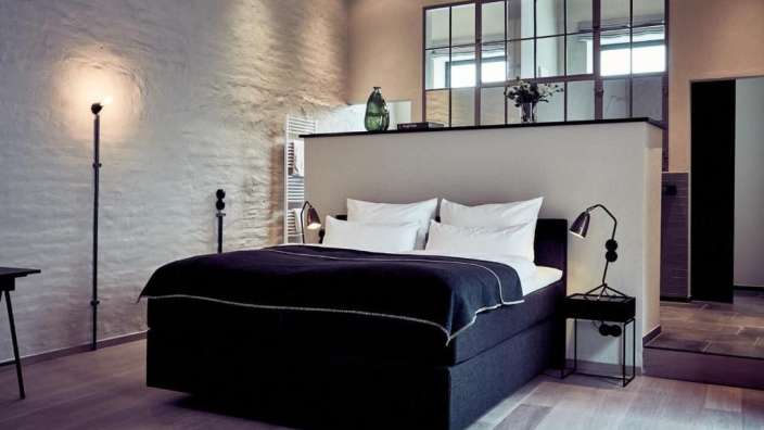 Ein Schlafzimmer mit einem schwarzen Bett und weißen Kissen