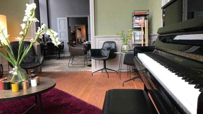 Ein hohner-Klavier steht in einem Wohnzimmer