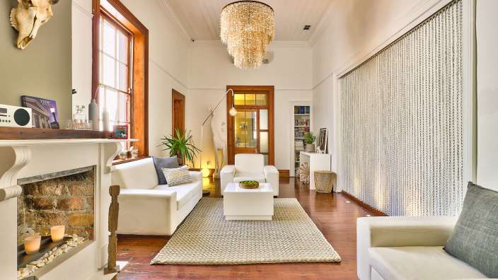 Ein Wohnzimmer mit weißen Möbeln und einem Kamin