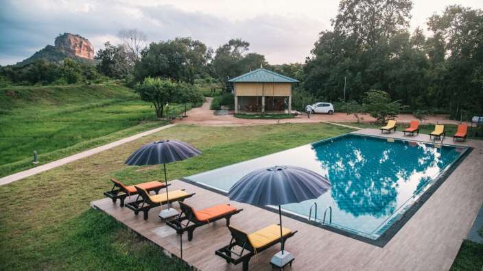 Ein großer Pool mit Liegestühlen und Sonnenschirmen davor