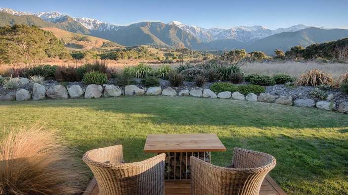 Ein Tisch und Stühle auf einer Terrasse mit Blick auf die Berge