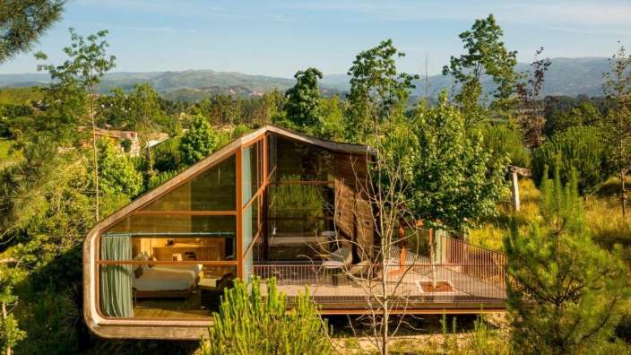 Ein kleines Haus mit vielen Fenstern inmitten eines Waldes