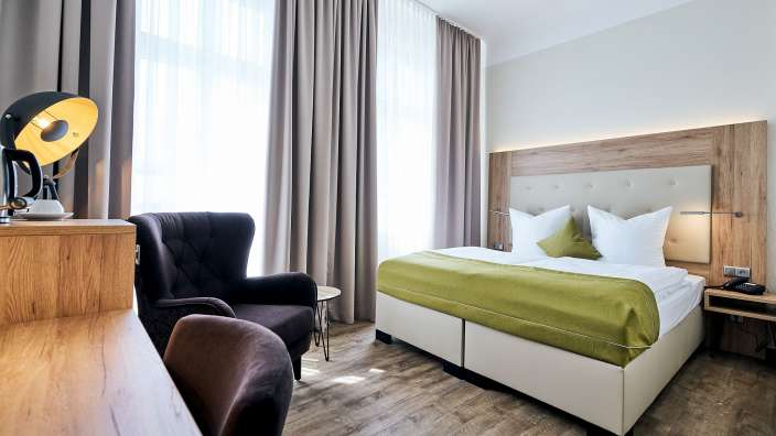 Ein Hotelzimmer mit einem Bett und einem Stuhl