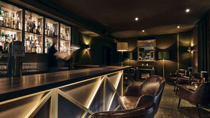 Ein Mann steht an einer Bar und hält ein Tablett in der Hand