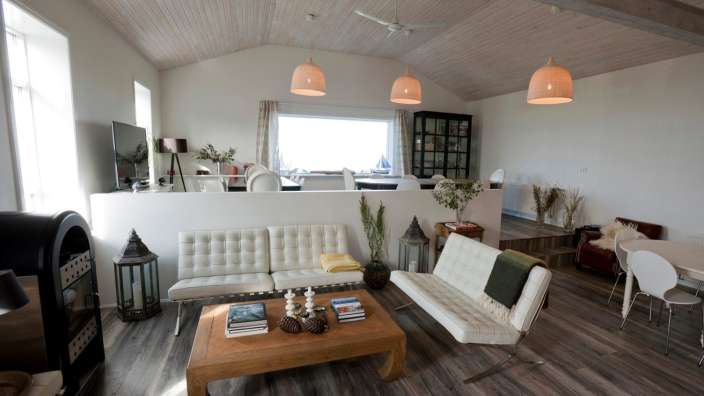 Ein Wohnzimmer mit weißen Möbeln und einem Holztisch