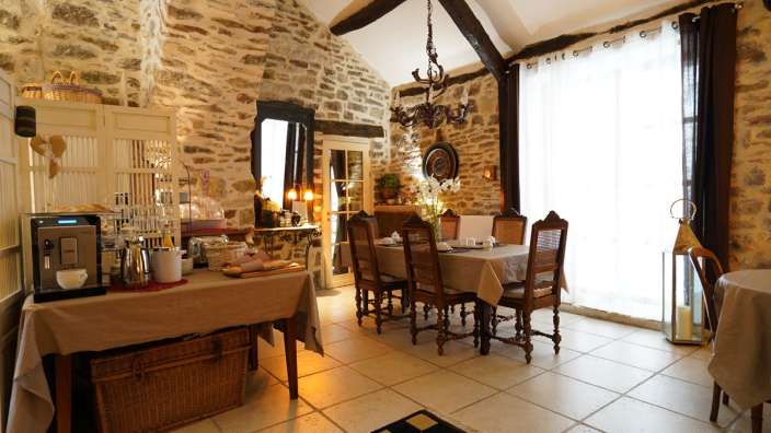 Ein Esszimmer mit einem Tisch und Stühlen und einer Kaffeemaschine