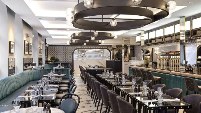 Eine lange Reihe von Tischen und Stühlen in einem Restaurant
