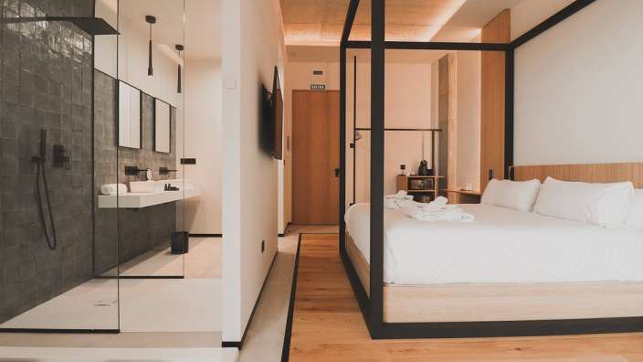 Ein Hotelzimmer mit einem Himmelbett und einem Badezimmer