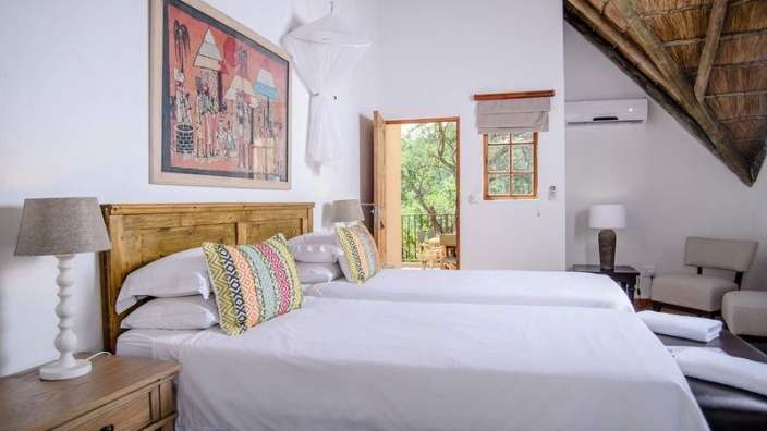 Ein Schlafzimmer mit zwei Betten und einem Gemälde an der Wand