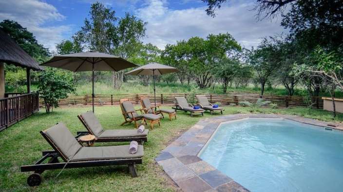 Ein Pool mit Liegestühlen und Sonnenschirmen umgeben