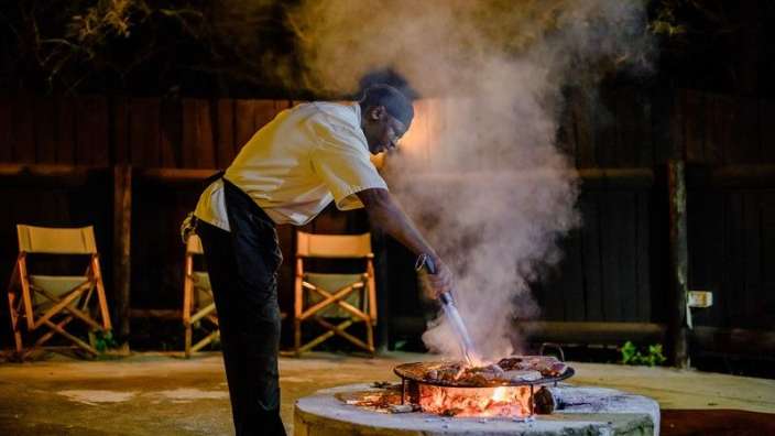Ein Mann bereitet Essen auf einem Grill vor