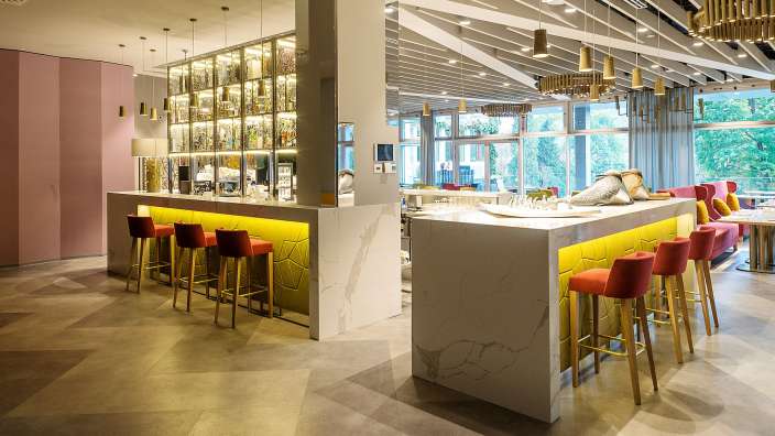 Ein Restaurant mit einer langen Bar und roten Hockern