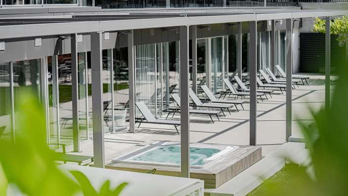 Ein großes Gebäude mit vielen Fenstern und Liegestühlen