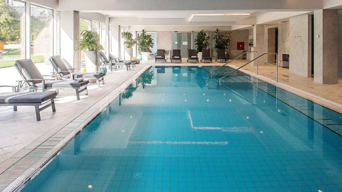 Ein großer Schwimmbad mit vielen Stühlen und Pflanzen