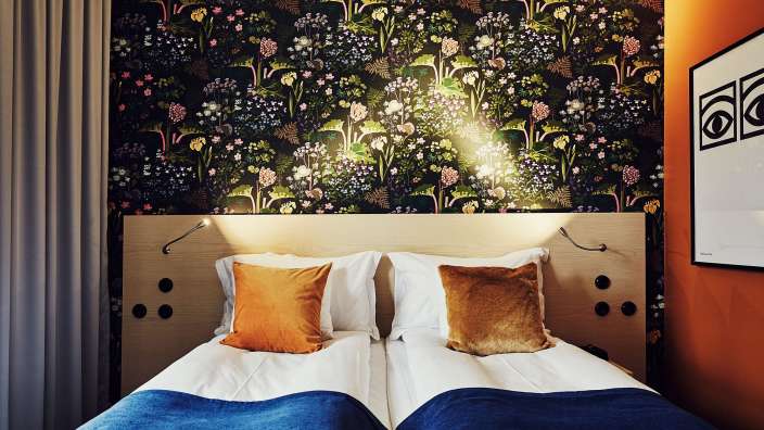 Ein Schlafzimmer mit zwei Betten und einer Blumentapete