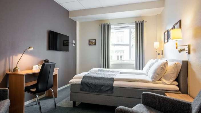 Ein Hotelzimmer mit zwei Betten und einem Fernseher