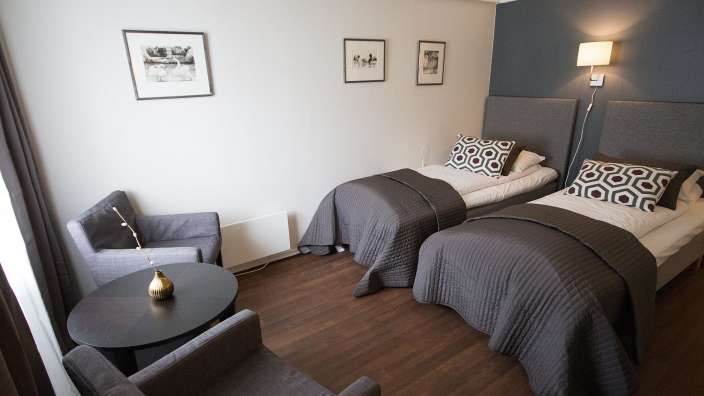 Ein Hotelzimmer mit zwei Betten und einem Tisch