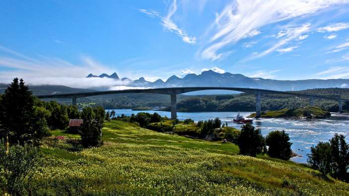 Eine Brücke über einen Fluss mit Bergen im Hintergrund