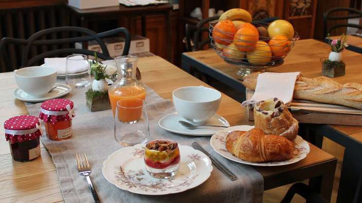 Ein tisch mit tellern und gläsern mit marmelade und croissants