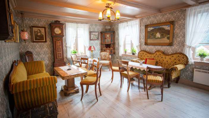 Ein Wohnzimmer mit einem Tisch und Stühlen und einer Uhr