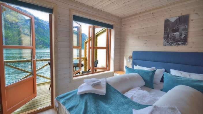 Ein Schlafzimmer mit einem Bett und einem Fenster mit Blick auf einen See