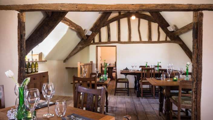Ein Esszimmer mit Holzböden und Holzbalken