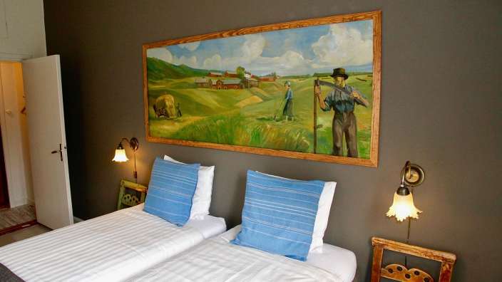 Ein Schlafzimmer mit zwei Betten und einem Gemälde an der Wand