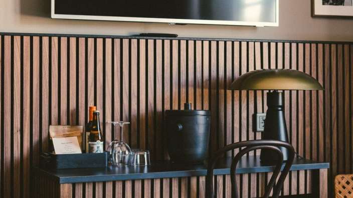 Ein Schreibtisch mit einer Lampe und einem Fernseher darauf