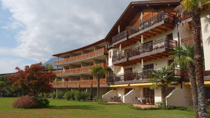 Ein großes Gebäude mit vielen Balkonen und Bäumen