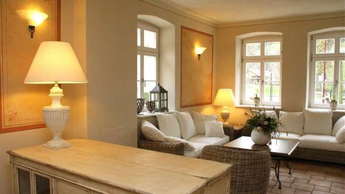 Ein Wohnzimmer mit weißen Möbeln und Lampen