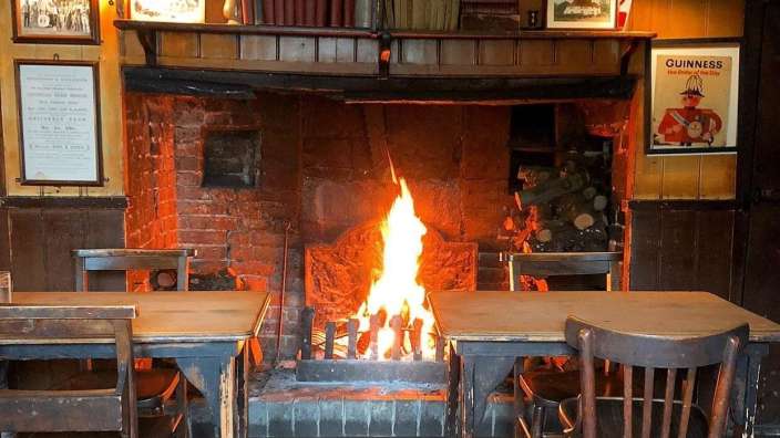 Ein Kamin mit einem guinness-Poster darüber