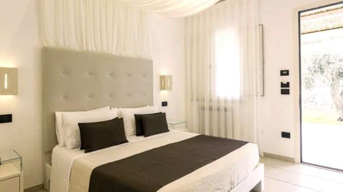 Ein weißes Schlafzimmer mit einem Bett und einer Tür