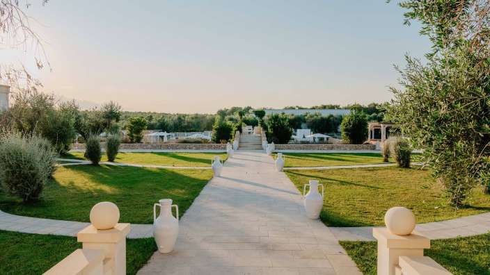 Ein weißer Gehweg mit weißen Vasen an der Seite