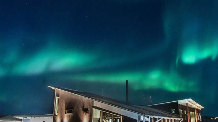 Das Nordlicht scheint über einem großen Gebäude