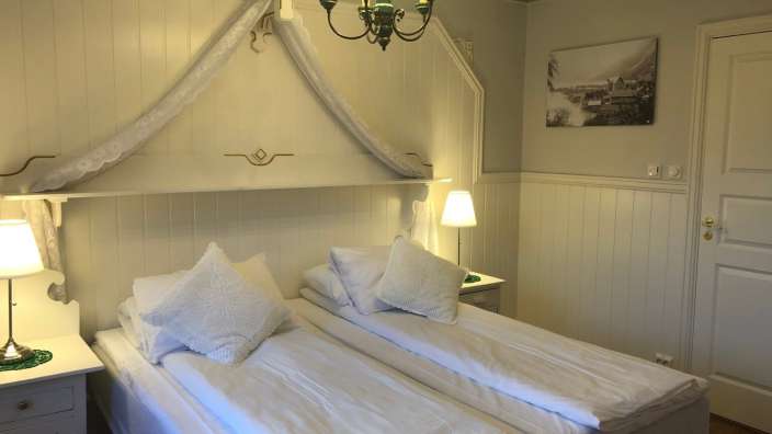 Ein Schlafzimmer mit zwei Betten und einem Bild an der Wand