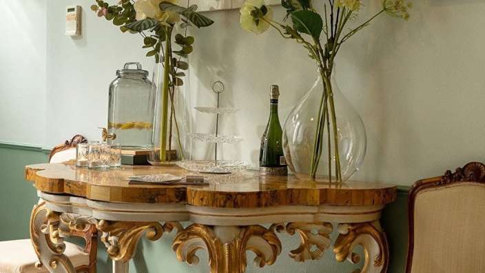 Eine Flasche Champagner steht auf einem Tisch neben einer Vase mit Blumen