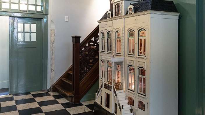 Ein Puppenhaus steht in einem Flur neben einer Treppe