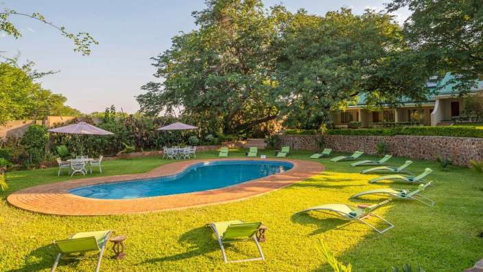 Ein großer Pool mit Stühlen und Sonnenschirmen um ihn herum
