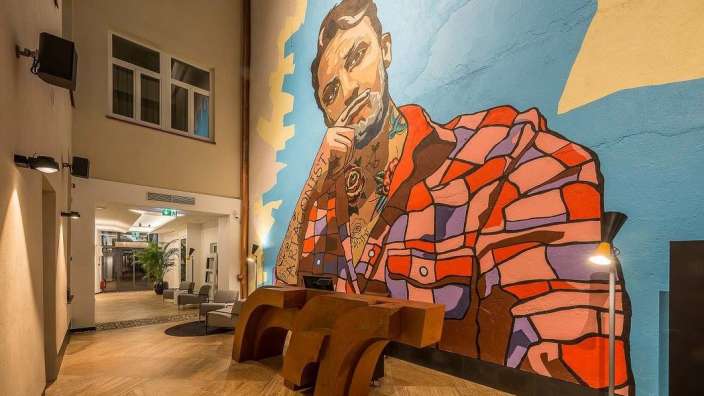 Ein großes Wandbild eines Mannes mit einem Tattoo auf seinem Gesicht