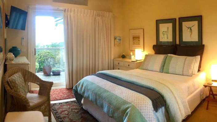 Ein Schlafzimmer mit einem Bett und einem Weidenstuhl