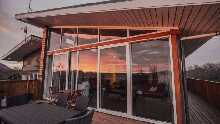 Ein Haus mit vielen Fenstern und einem Tisch und Stühlen