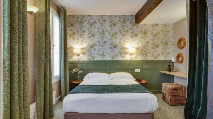 Ein kleines Schlafzimmer mit einem Bett und grünen Vorhängen