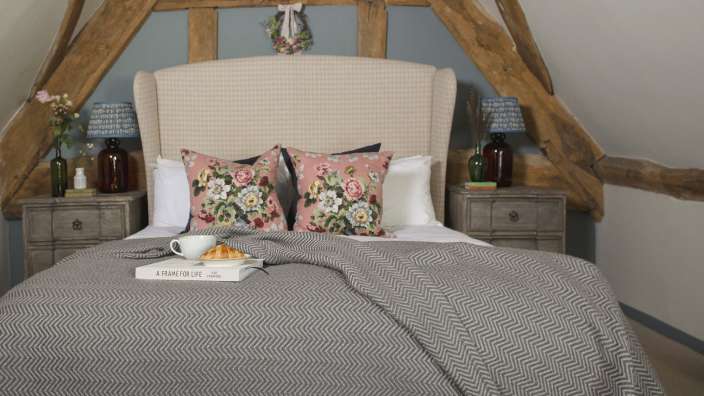 Ein Bett mit einem Buch und einer Tasse Kaffee darauf