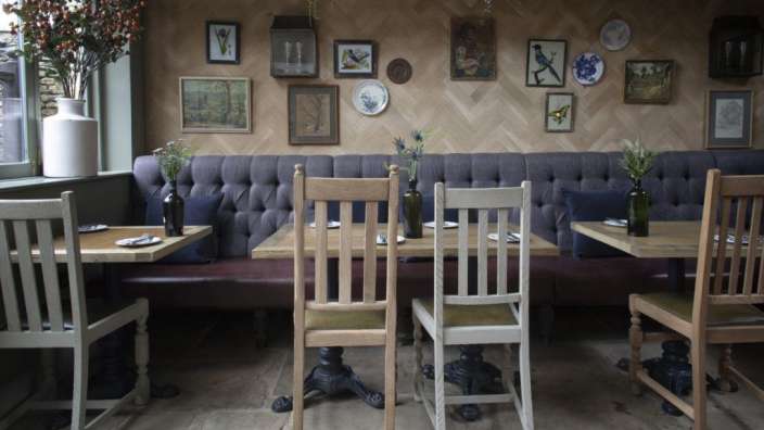 Tische und Stühle in einem Restaurant mit Bildern an der Wand