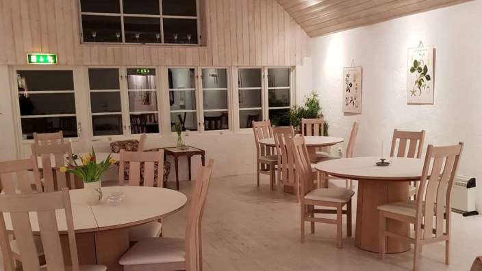 Ein Esszimmer mit weißen Tischen und Stühlen